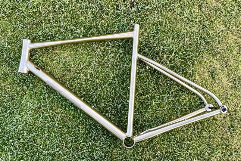 A bare brushed titanium frame on grass