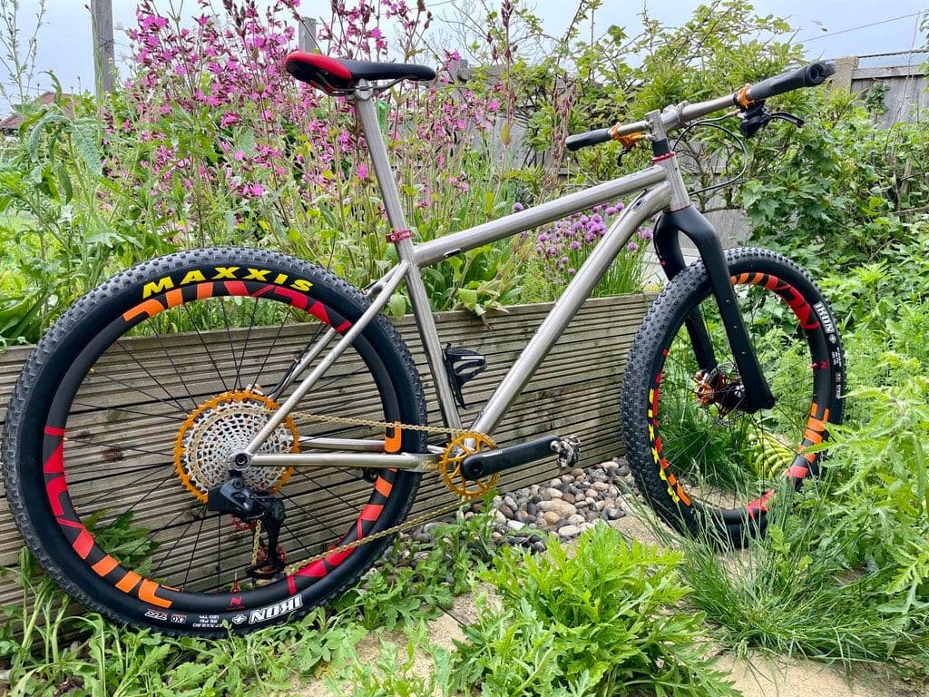 A titanium mountain bike on a garden path